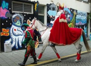 Sinterklaas kommer sejlende fra Spanien til Holland. Derefter rider han på en hvid skimmel rundt i byerne, mens hans sorte hjælpere uddeler pebernødder og godter til børnene.