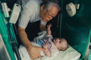Print fra filmen The Drop Box, hvor pastor Lee Jong-rak finder endnu en baby efterladt i den varme luge i sit hus.