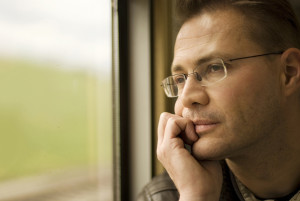Thinking man looking out of window, in the train